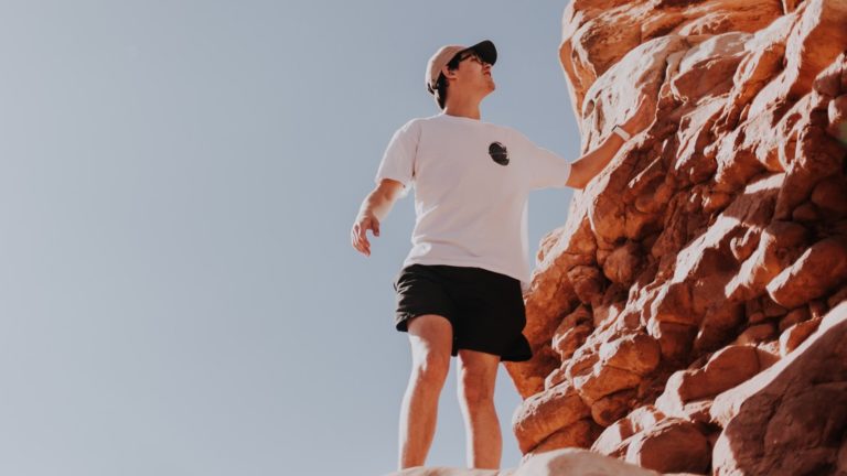 自然岩でボルダリングを行う男性